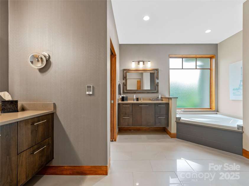 3 Turkey Roost Court, Fairview, NC 28730.  MLS# CAR4273755, YatesRealty ID 22782. Primary bathroom with double vanitiies, bath, walk in shower, toilet and linen closet