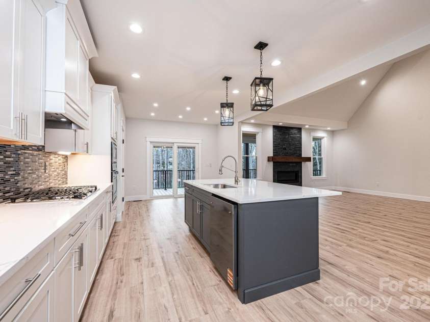 1328 33rd Avenue Drive, Hickory, NC 28601.  MLS# CAR4327859, YatesRealty ID 2279. Large Kitchen Island with Breakfast Bar, Sink, Open Floor plan to 2-story Great Room with FireplaceCabinets are white with soft close drawers..