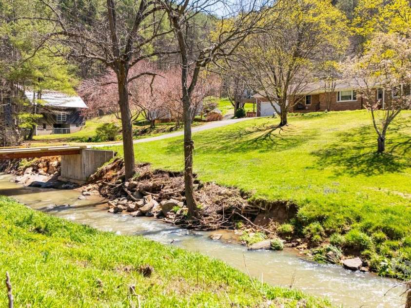 6334 Jacks Creek Road, Burnsville, NC 28714.  MLS# CAR4259403, YatesRealty ID 22798. Follow the creek home and cross over the bridge to your 18 acre farm with 2 homes and barn, in the Blue Ridge Mountains.