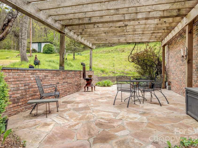 6334 Jacks Creek Road, Burnsville, NC 28714.  MLS# CAR4259403, YatesRealty ID 22798. The hummingbirds love the grape vines that cover the arbor.