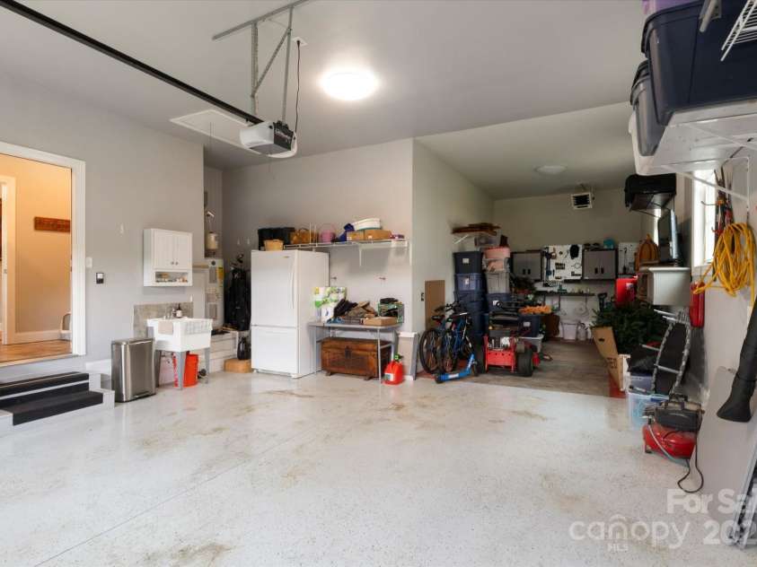 91 Triple Fairways Drive, Hendersonville, NC 28739.  MLS# CAR4265279, YatesRealty ID 22810. Over Size Double Car Garage has a Large Workshop Area or Storage Area Plus Pull Down Attic Stairs fr More Storage