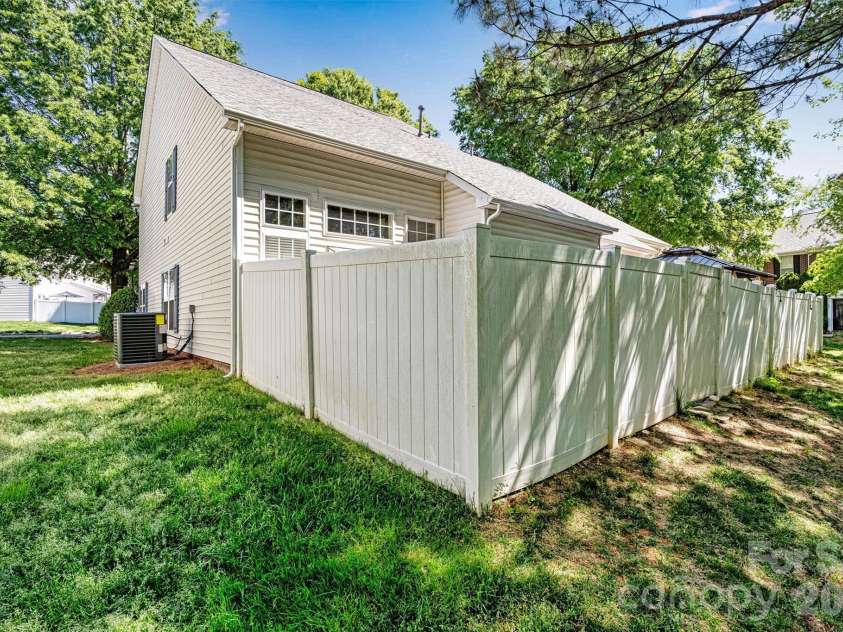 151 Talbert Town Loop, Mooresville, NC 28117.  MLS# CAR4367456, YatesRealty ID 22845. End unit with rear privacy fence surrounded by mature trees.
