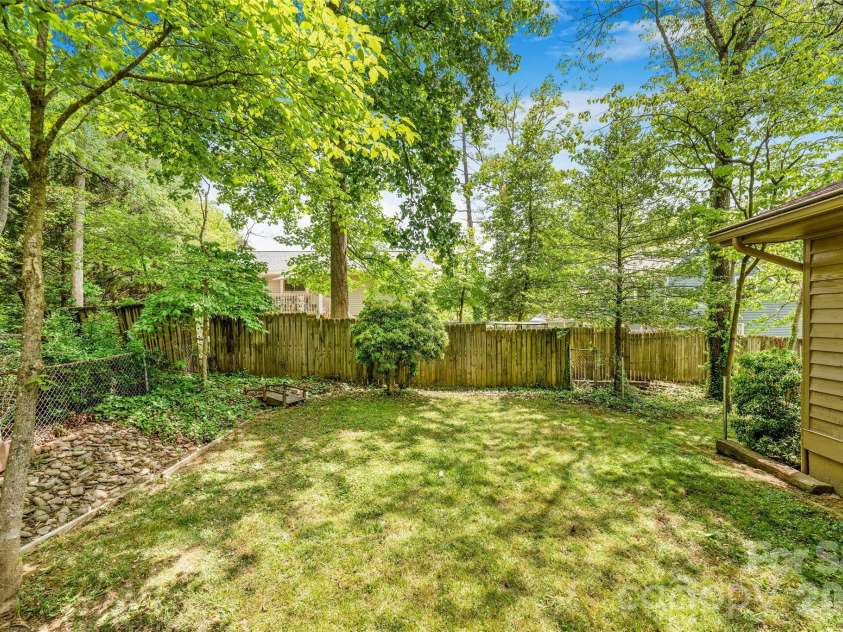 135 Scarlet Drive, Fletcher, NC 28732.  MLS# CAR4373929, YatesRealty ID 22883. Backyard with mature trees. 