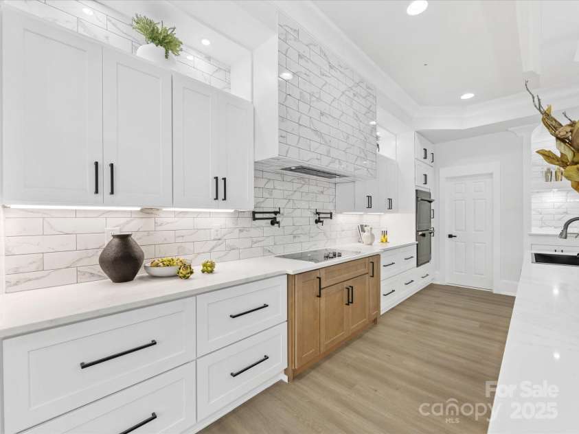 5217 Waterfall Court, Gastonia, NC 28056.  MLS# CAR4268389, YatesRealty ID 22901. Kitchen w/ vented hood and induction cook top. Door at end leads to walk in pantry