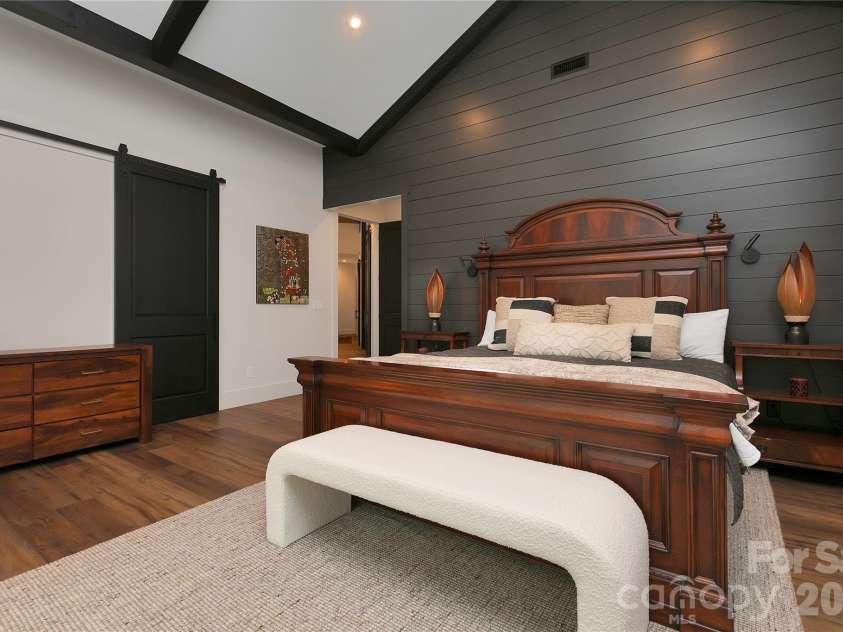 726 Ugugu Drive, Brevard, NC 28712.  MLS# CAR4374214, YatesRealty ID 22985. Designed for comfort and visual impact, the primary suite showcases soaring ceilings with striking exposed wood beams.