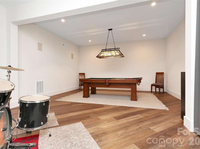 726 Ugugu Drive, Brevard, NC 28712.  MLS# CAR4374214, YatesRealty ID 22985. Lower level includes a dedicated game room with a pool table, providing a comfortable and casual space for recreation and downtime.