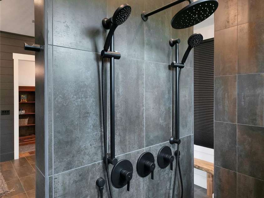 726 Ugugu Drive, Brevard, NC 28712.  MLS# CAR4374214, YatesRealty ID 22985. The expansive primary shower offers a spa like experience, featuring dual openings, multiple shower heads and a built in bench for ultimate relaxation.