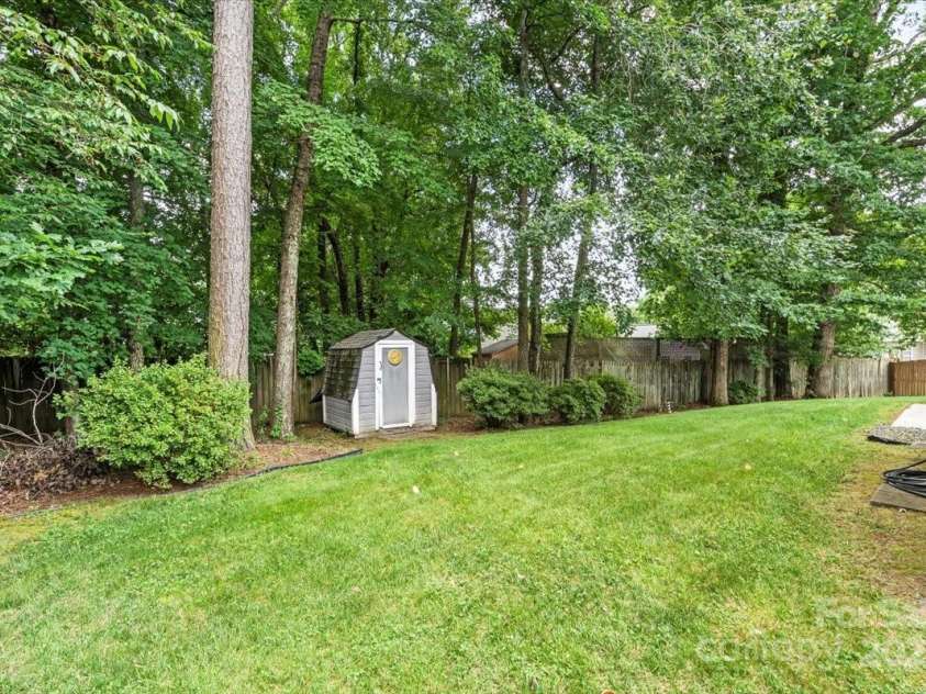 3114 Pine Pointe Street, Matthews, NC 28104.  MLS# CAR4270613, YatesRealty ID 23026. Storage shed and flat backyard with beautiful azaleas