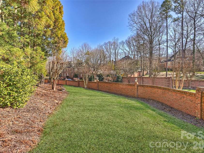 5242 Colony Road, Charlotte, NC 28226.  MLS# CAR4337225, YatesRealty ID 23103. Stately brick perimeter wall frames rear lawn