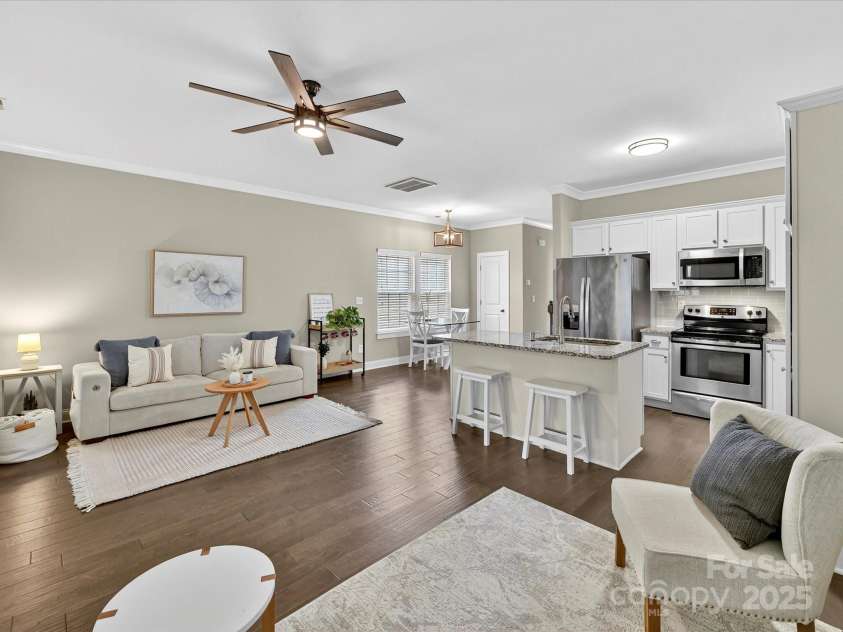 12220 Huntersville Concord Road, Huntersville, NC 28078.  MLS# CAR4301471, YatesRealty ID 23109. Open Floor plan living room and kitchen area. 5' Hardwood floors, granite countertop, stainless steel appliances , crown molding and ceiling fan with light