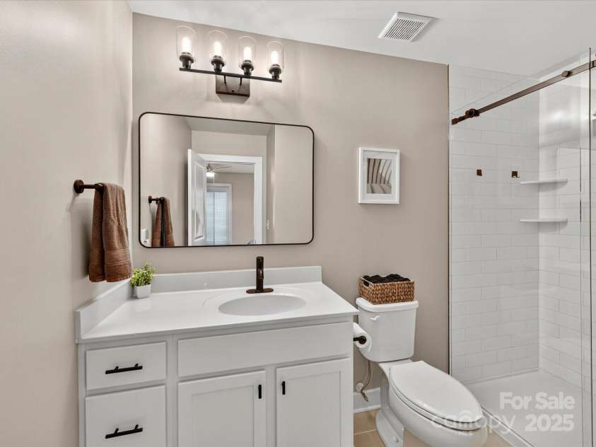 12220 Huntersville Concord Road, Huntersville, NC 28078.  MLS# CAR4301471, YatesRealty ID 23109. Primary bathroom with new vanity , fixtures and elegantly tiled walk in shower