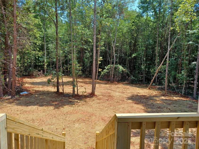 372 Lippard Farm Road, Statesville, NC 28625.  MLS# CAR4275109, YatesRealty ID 23117. Rear yard is partially cleared for entertaining but surrounded by peaceful shady woods...