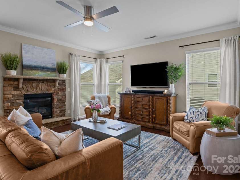 2007 Bishops Court, Cornelius, NC 28031.  MLS# CAR4257347, YatesRealty ID 23133. Bright and airy Living Room features crown molding and stone fireplace.