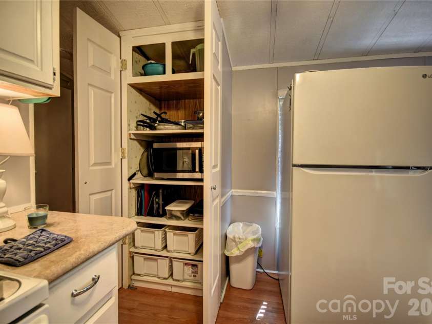 91 Mallard Loop, Waynesville, NC 28785.  MLS# CAR4372848, YatesRealty ID 23150. Refrigerator and pantry across from the kitchen