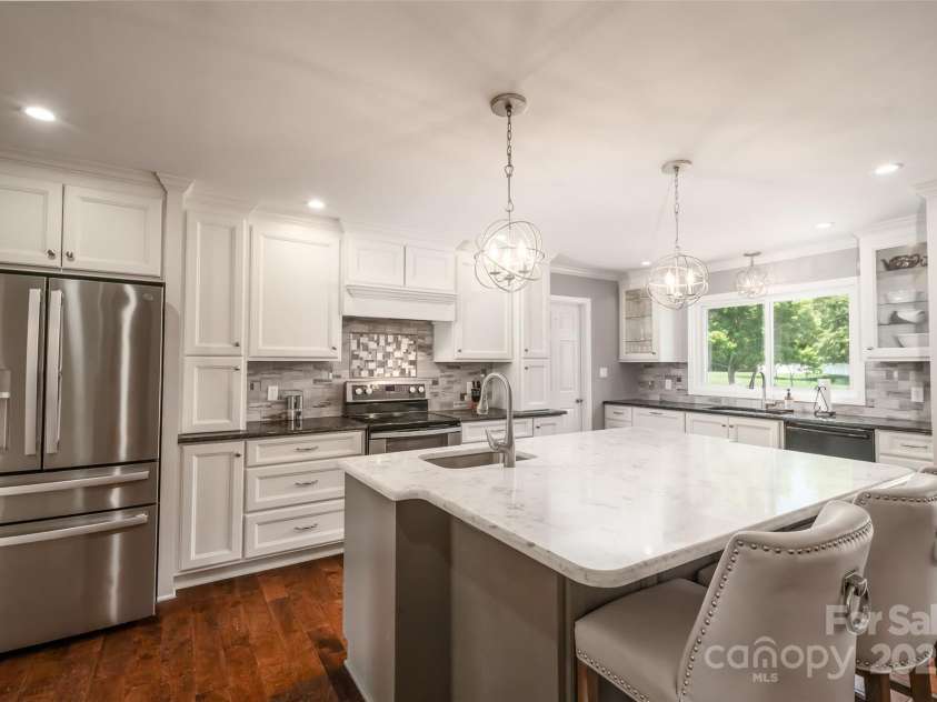 139 Hardwick Drive, Mooresville, NC 28115.  MLS# CAR4270684, YatesRealty ID 23196. The kitchen is stunning with granite, a huge island with vegetable sink and seating space and stainless steel appliances