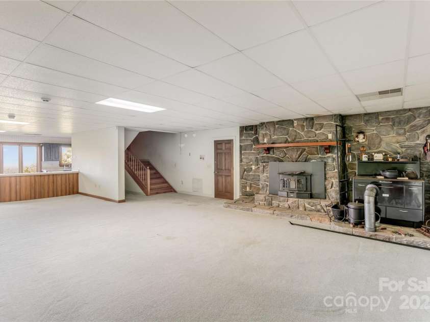 1087 Brigadoon Drive, Clyde, NC 28721.  MLS# CAR4276623, YatesRealty ID 23272. Lower level family room with fireplace