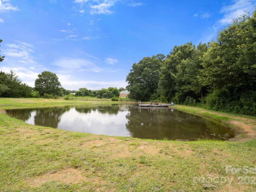 3451 Greene Road, Monroe, NC 28110.  MLS# CAR4271557, YatesRealty ID 23327. Fully stocked private pond with wooden Dock