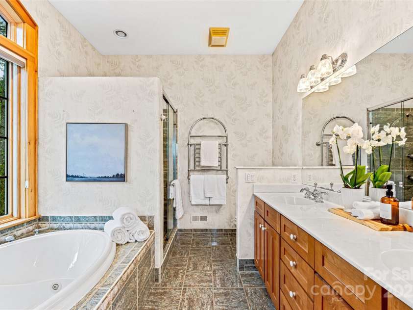 1987 Rabbit Hop Road, Spruce Pine, NC 28777.  MLS# CAR4270357, YatesRealty ID 23328. Primary Bath with double vanity, tile shower and soaking tub with views