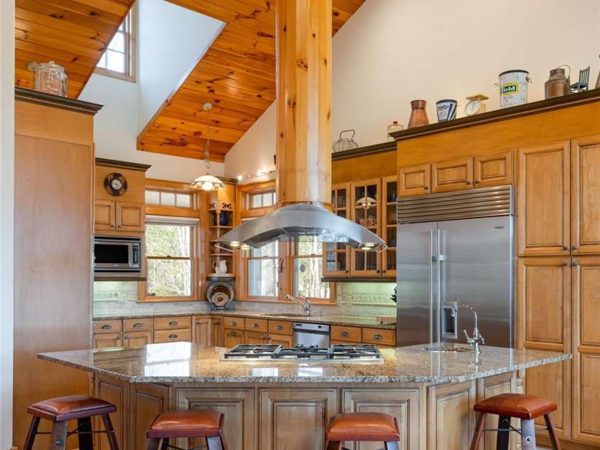 1987 Rabbit Hop Road, Spruce Pine, NC 28777.  MLS# CAR4270357, YatesRealty ID 23328. The main residence showcases soaring tongue-and-groove ceilings, a floor-to-ceiling stone fireplace