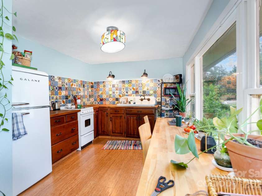 4124 Oakwood Road, Charlotte, NC 28269.  MLS# CAR4276165, YatesRealty ID 23335. Beautifully decorated kitchen with farmhouse sink and seating area overlooking the picture window