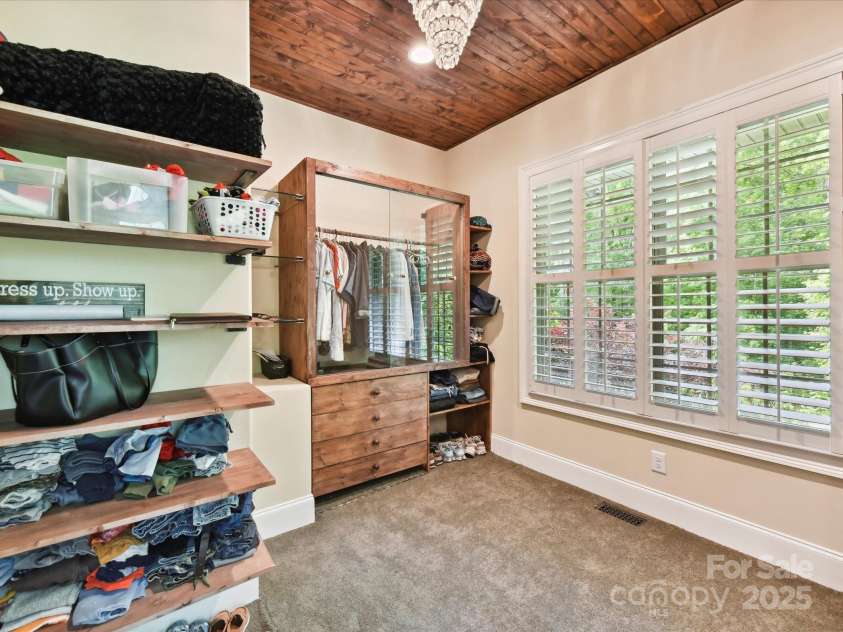 633 Elmhurst Drive, Fort Mill, SC 29715.  MLS# CAR4245784, YatesRealty ID 23352. Primary bedroom features custom walk in closet , primary bath, Tray ceiling with crown molding, large bay windows and recessed lighting create an airy, elegant vibe. The room feels serene and spacious, with earthy tones