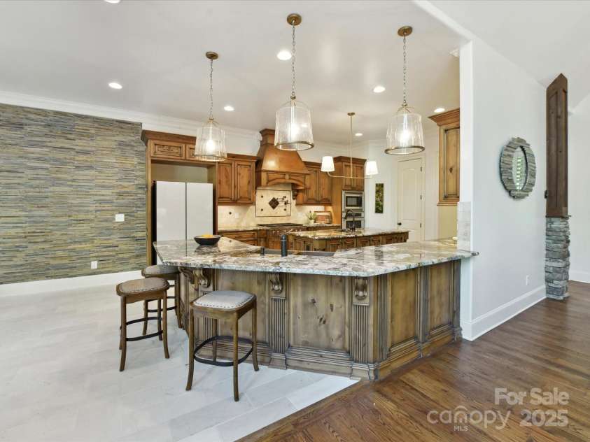 633 Elmhurst Drive, Fort Mill, SC 29715.  MLS# CAR4245784, YatesRealty ID 23352. The kitchen exudes elegance and functionality boasting a huge exotic granite breakfast bar and island, built in Wolf Stove, wall oven, 2 dishwashers, copper double farm sink & prep sink, pot filler, warming drawers, win
