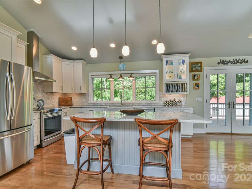 63 Greenridge Road, Weaverville, NC 28787.  MLS# CAR4268175, YatesRealty ID 23413. Exit the kitchen out onto the rear deck.  Doors and windows opposite one another make dreams of cool summer cross breezes a reality.