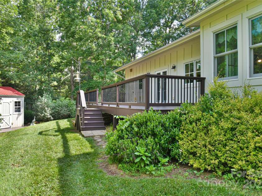 63 Greenridge Road, Weaverville, NC 28787.  MLS# CAR4268175, YatesRealty ID 23413. Rear deck looks out onto back yard, framed by foliage.