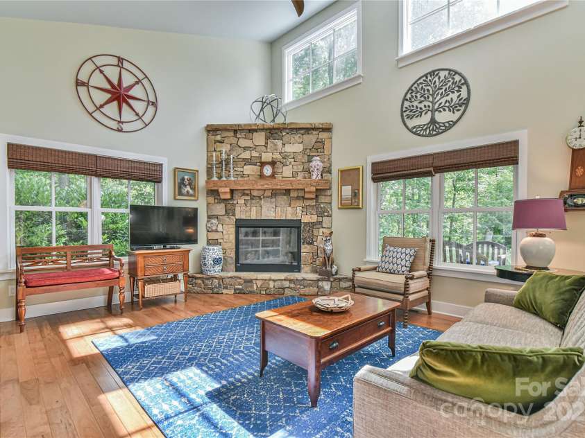 63 Greenridge Road, Weaverville, NC 28787.  MLS# CAR4268175, YatesRealty ID 23413. Stone fireplace flanked by nature through two sets of windows is sure to be a winter attraction.