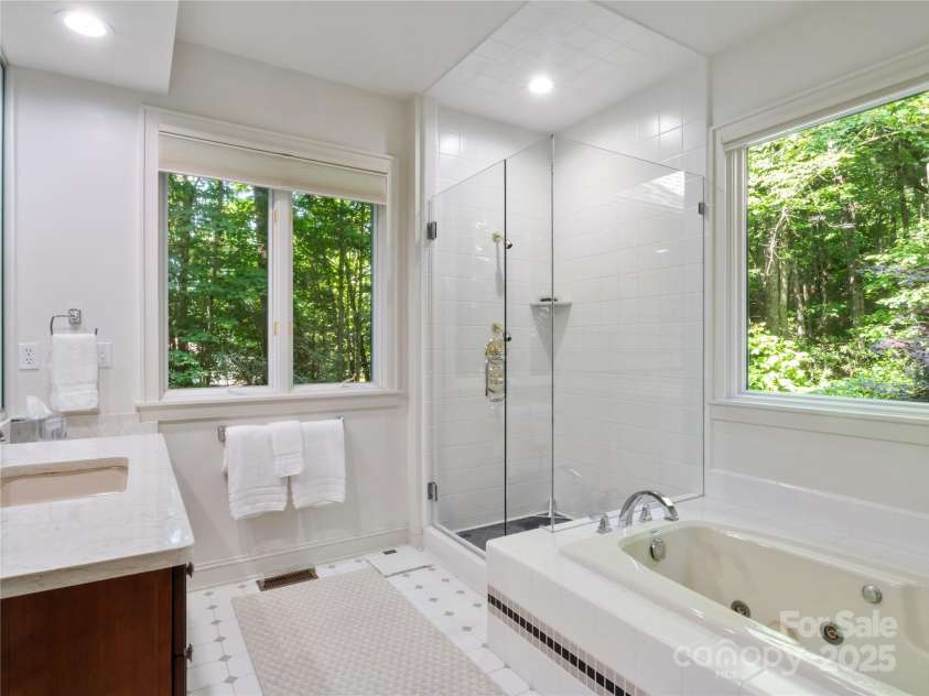 201 Didrikson Way, Hendersonville, NC 28739.  MLS# CAR4275546, YatesRealty ID 23432. Enjoy the updated spa-inspired bath, featuring a stunning tile shower enclosed with glass for a modern, open feel.