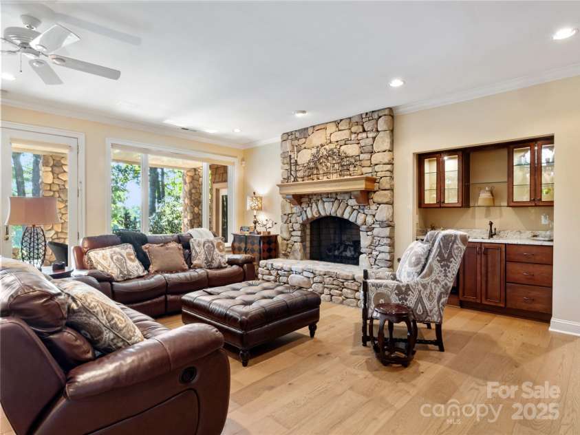 201 Didrikson Way, Hendersonville, NC 28739.  MLS# CAR4275546, YatesRealty ID 23432. The spacious lower-level family room features a dramatic floor-to-ceiling stone fireplace and a built-in wet bar—perfect for entertaining.