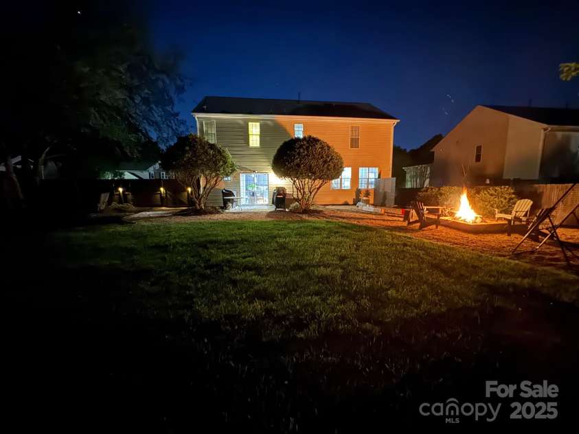 8140 Laurel Run Drive, Charlotte, NC 28269.  MLS# CAR4244296, YatesRealty ID 23451. Nighttime Fire Pit and Yard