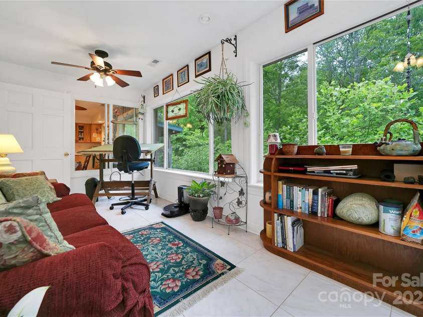229 Hubbard Hollow Road, Rosman, NC 28772.  MLS# CAR4264936, YatesRealty ID 23454. On the back side of the house towards the side door to the garage is the second / rear sunroom. Huge windows make this room a great place to relax and enjoy a book, or can be a place to work, on anything you desire.
