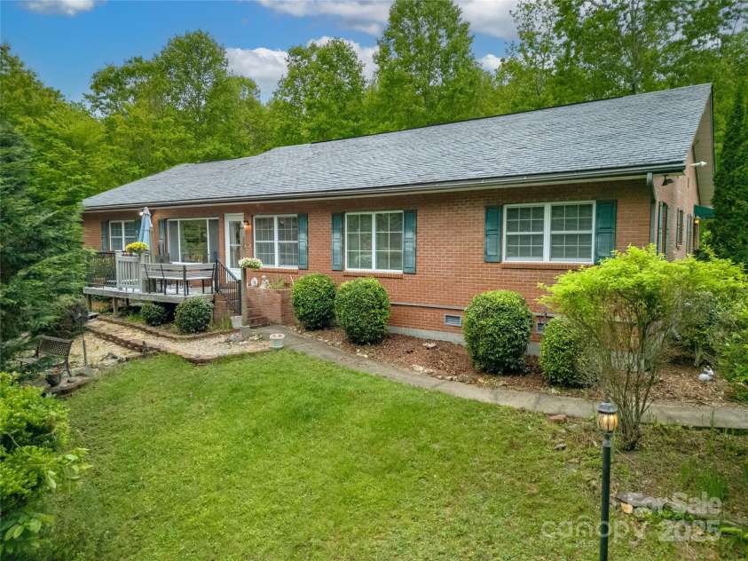 229 Hubbard Hollow Road, Rosman, NC 28772.  MLS# CAR4264936, YatesRealty ID 23454. The nice level walkway from the garage side to the front deck, also leads to the front garden area over a small bridge. Very serene and private setting.!