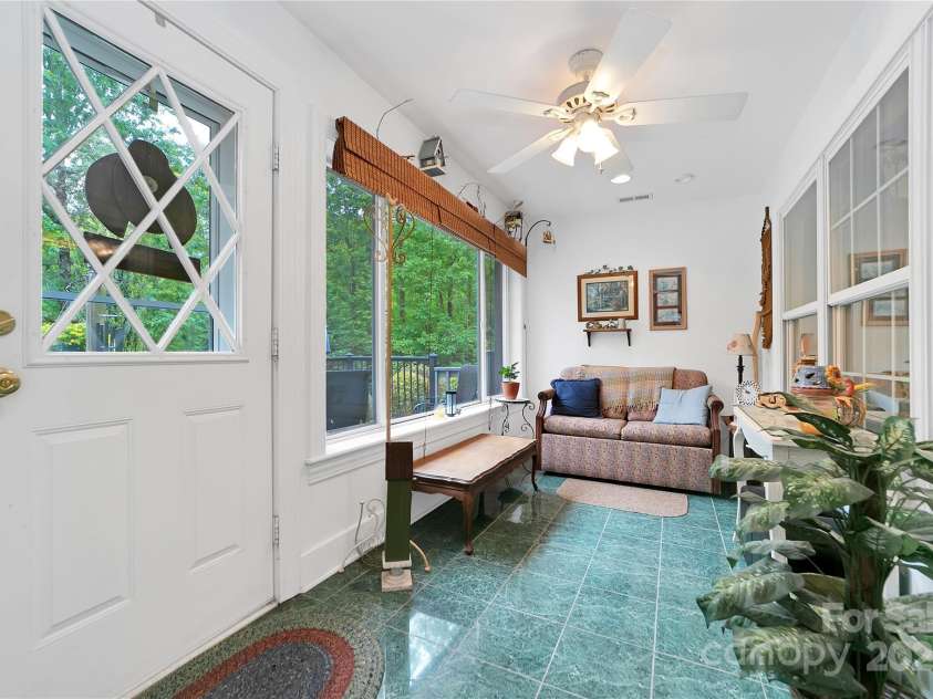 229 Hubbard Hollow Road, Rosman, NC 28772.  MLS# CAR4264936, YatesRealty ID 23454. The sunroom is just in from the front deck, very sunny and bright, a wonderful place to sit and read or converse.