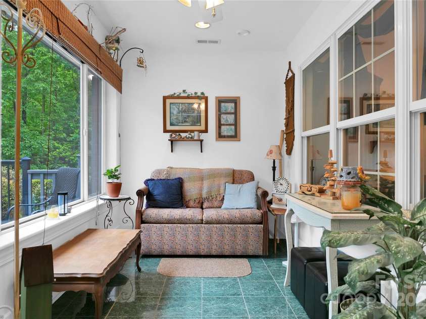 229 Hubbard Hollow Road, Rosman, NC 28772.  MLS# CAR4264936, YatesRealty ID 23454. The sunroom is sunny and bright, and by opening the interior windows to the adjacent living room, the space for entertaining grows.
