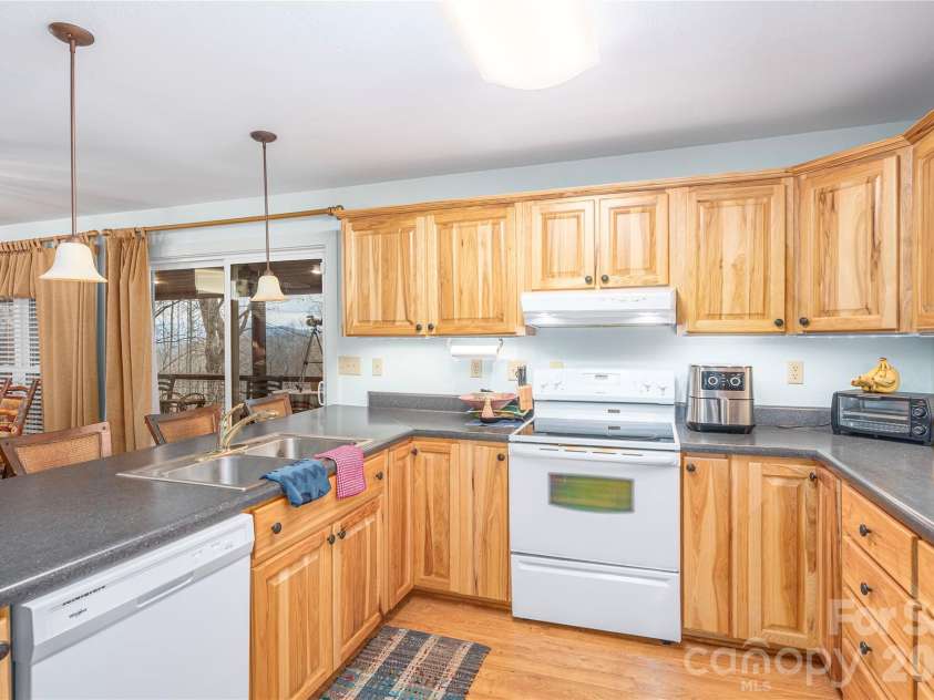 12 Bear Cove Lane, Bryson City, NC 28713.  MLS# CAR4337192, YatesRealty ID 2358. Lovely natural wood cabinets and dark counters contrast nicely with white appliances