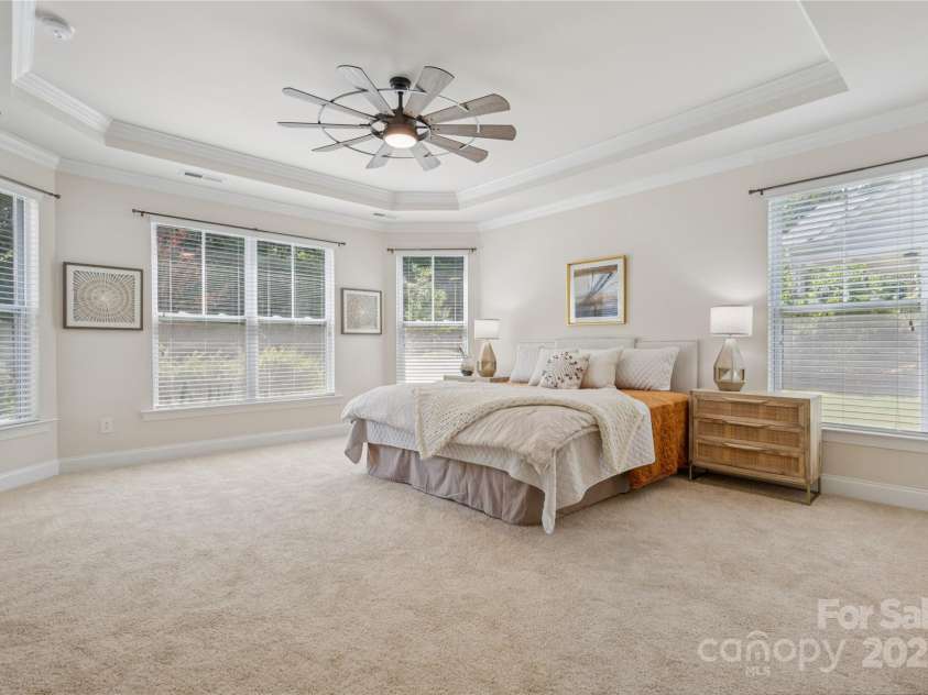 196 Hawks Creek Parkway, Fort Mill, SC 29708.  MLS# CAR4271545, YatesRealty ID 23591. Spacious Primary en suite with window seating area, ceiling fan & tray ceiling.