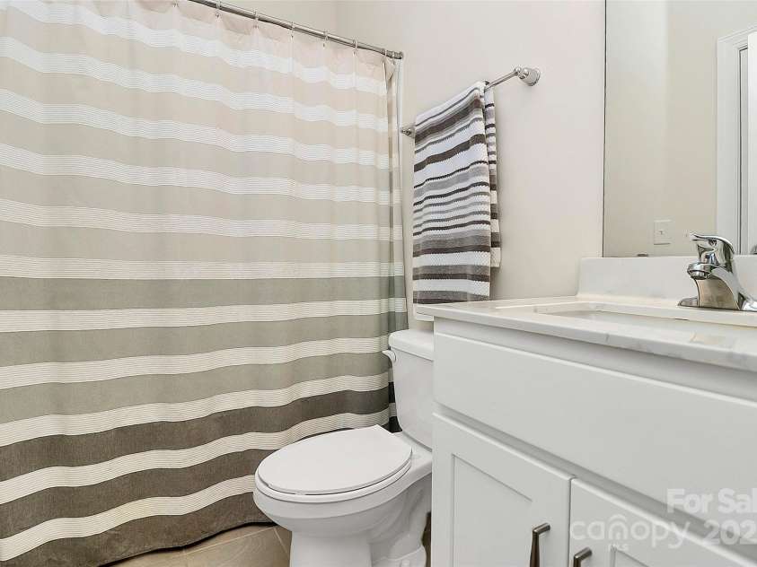 139 Suggs Mill Drive, Mooresville, NC 28115.  MLS# CAR4272116, YatesRealty ID 23610. Conveniently located on the first floor, this full bath features a tub/shower combo and a luxury-height vanity, combining comfort and style for everyday ease and guest use.
