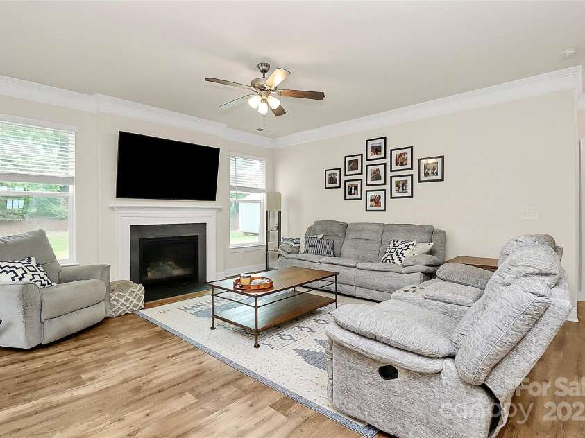 139 Suggs Mill Drive, Mooresville, NC 28115.  MLS# CAR4272116, YatesRealty ID 23610. Cozy up in the elegant family room featuring warm gas log fireplace and sophisticated crown molding. This inviting space blends comfort and style, perfect for relaxing or entertaining year-round.