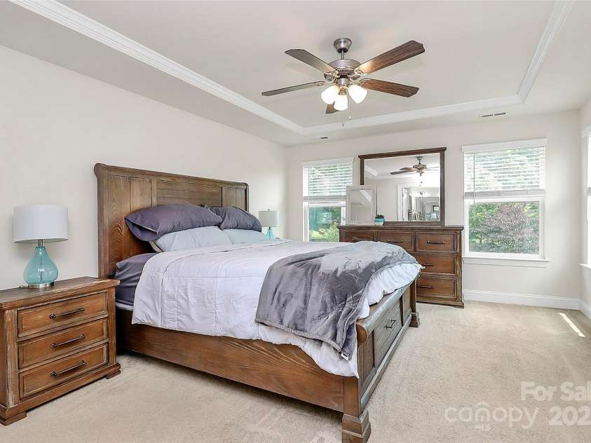 139 Suggs Mill Drive, Mooresville, NC 28115.  MLS# CAR4272116, YatesRealty ID 23610. The primary bedroom is filled with natural light and equipped with a ceiling fan, creating a bright, airy, and comfortable space to relax and unwind.