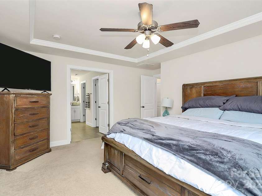 139 Suggs Mill Drive, Mooresville, NC 28115.  MLS# CAR4272116, YatesRealty ID 23610. The spacious primary bedroom features elegant double doors that open to the luxurious primary bathroom, creating a seamless and inviting retreat filled with light and style.