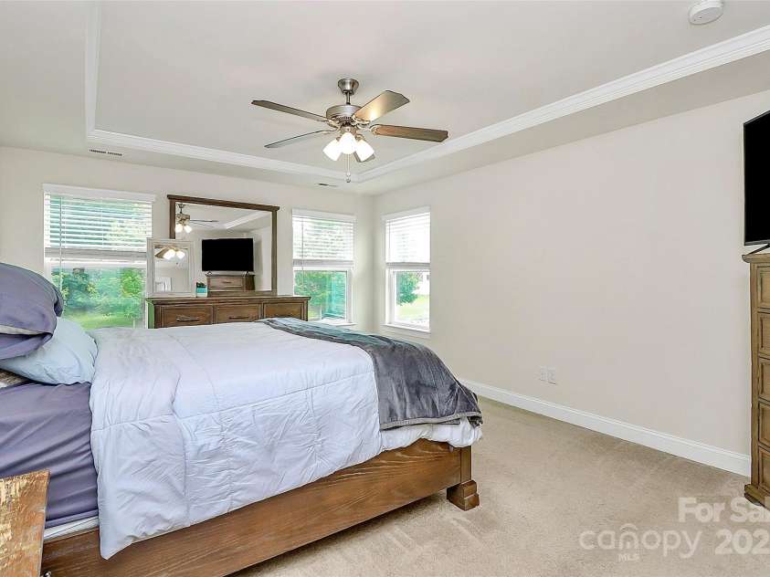 139 Suggs Mill Drive, Mooresville, NC 28115.  MLS# CAR4272116, YatesRealty ID 23610. The spacious primary bedroom on the second-floor features elegant tray ceilings, adding a touch of architectural sophistication to your serene retreat.
