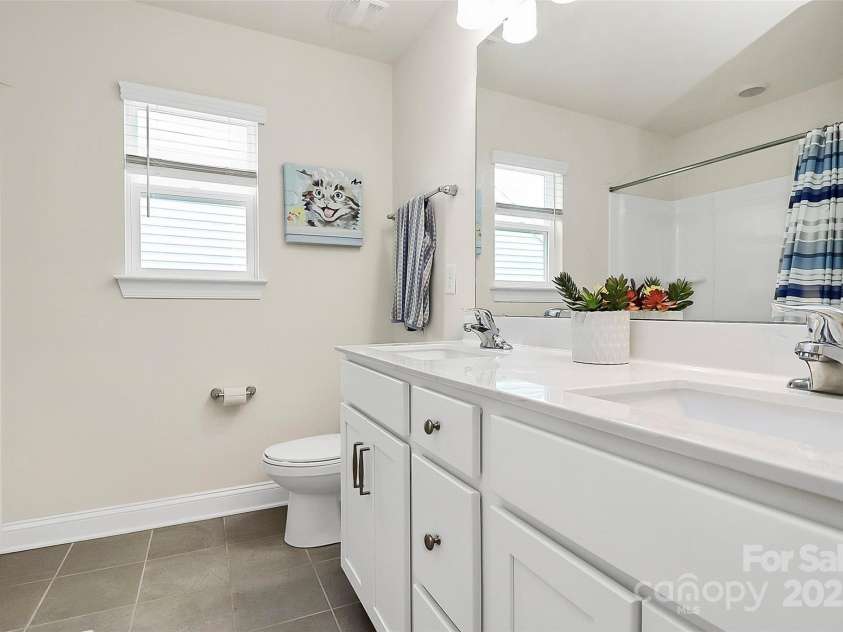 139 Suggs Mill Drive, Mooresville, NC 28115.  MLS# CAR4272116, YatesRealty ID 23610. This spacious shared bathroom features a double vanity, providing plenty of room for everyone to get ready comfortably and efficiently. Stylish and functional, it’s designed to meet the needs of busy households.