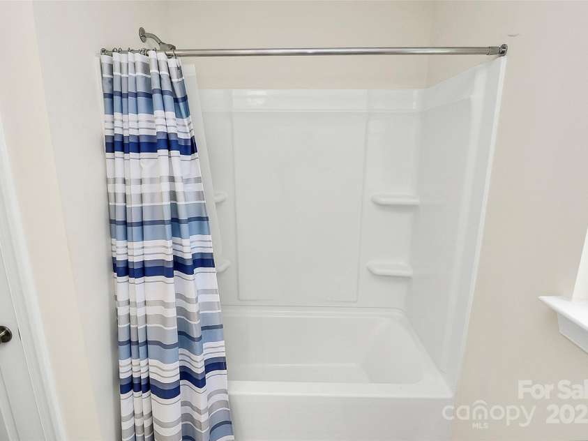 139 Suggs Mill Drive, Mooresville, NC 28115.  MLS# CAR4272116, YatesRealty ID 23610. This spacious shared bathroom offers a convenient tub/shower combo for versatile use and includes a handy linen closet for ample storage, combining practicality and comfort in one stylish space.