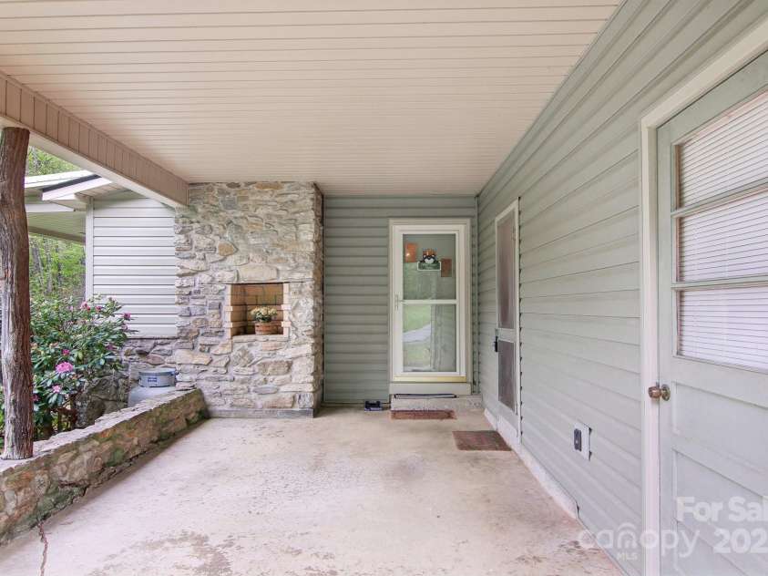 51 Atari Road, Waynesville, NC 28786.  MLS# CAR4256064, YatesRealty ID 23630. Left side of carport enters into open living area and kitchen