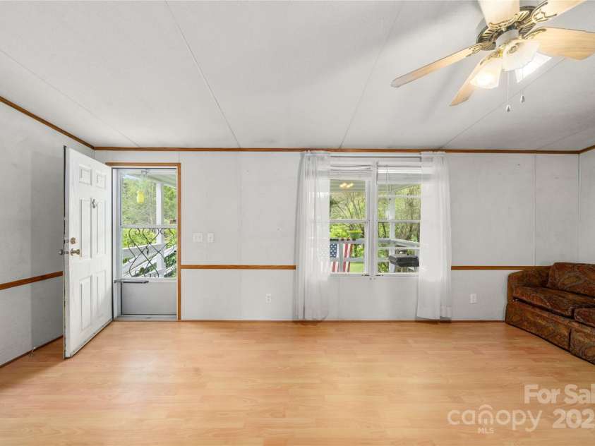 445 Old Holbert Road, Hendersonville, NC 28792.  MLS# CAR4259168, YatesRealty ID 23632. Living room connects to the covered porch