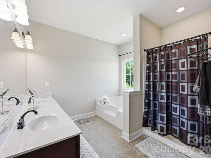 1434 Steeplechase Drive, Mount Pleasant, NC 28124.  MLS# CAR4378716, YatesRealty ID 23653. The Primary Bathroom is a large open-concept space that offers dual-vanity sinks and a soaking tub perfect for relaxing after a long day!