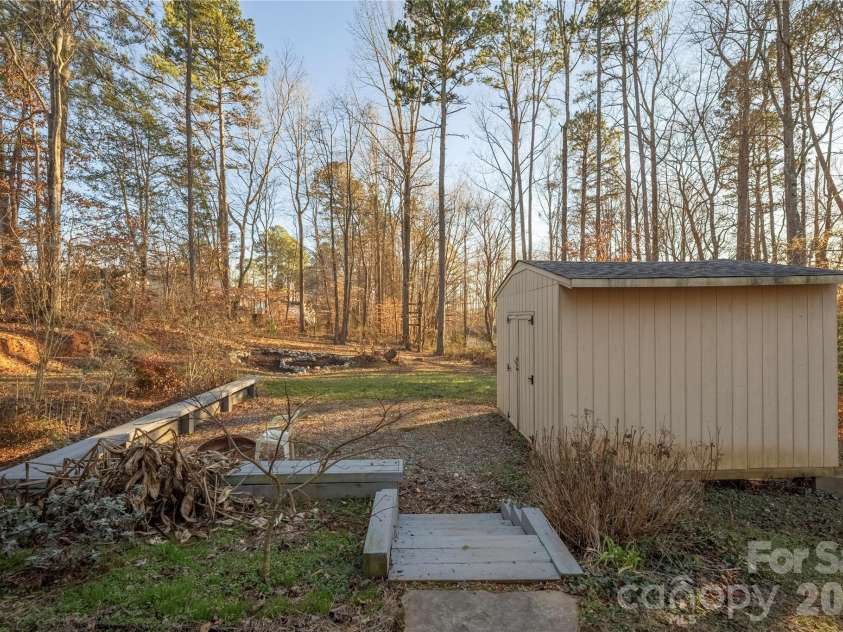107 Barndale Drive, Troutman, NC 28166.  MLS# CAR4340490, YatesRealty ID 2366. Large shed for storage and built in benches for a relaxing night around the fire pit.