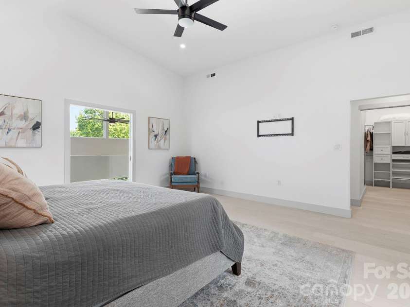 22 Lara Drive, Mills River, NC 28759.  MLS# CAR4382358, YatesRealty ID 23687. Luxurious primary bedroom featuring oversized windows, high ceilings, private balcony access, and custom walk-in closet.